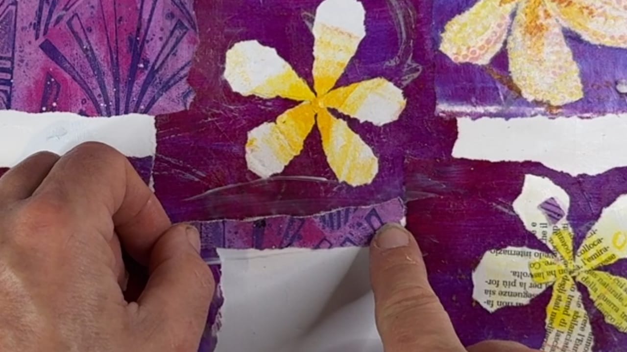 Hands creating a torn paper collage of frangipani / plumeria flowers. Top down view