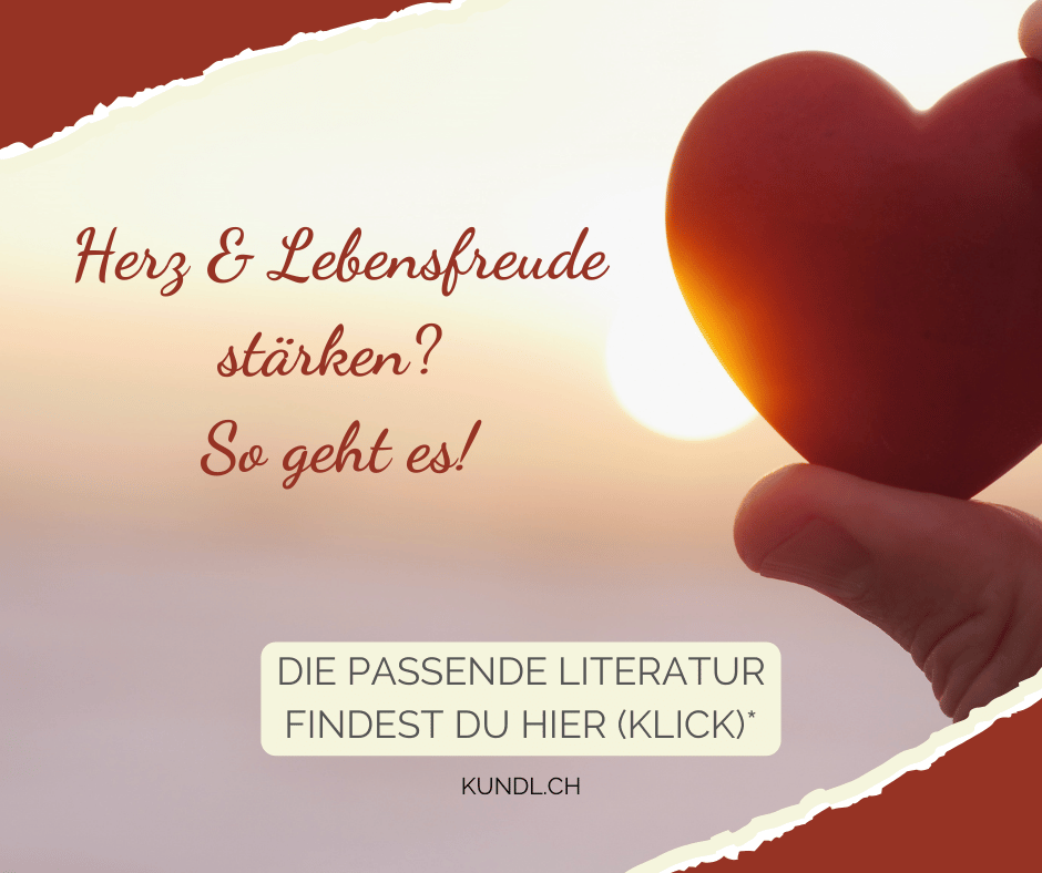 rotes Herz zwischen den Fingern gehalten vor einer Sonne