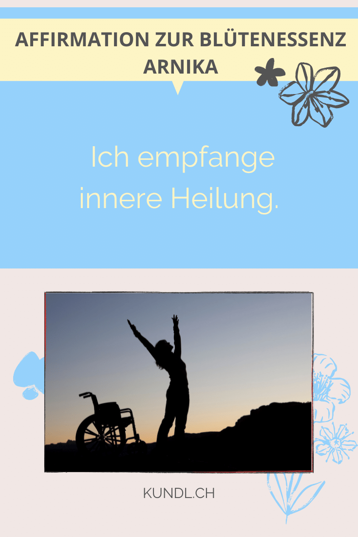 Person in der Dämmerung, welche in einer Siegerpose neben dem Rollstuhl steht