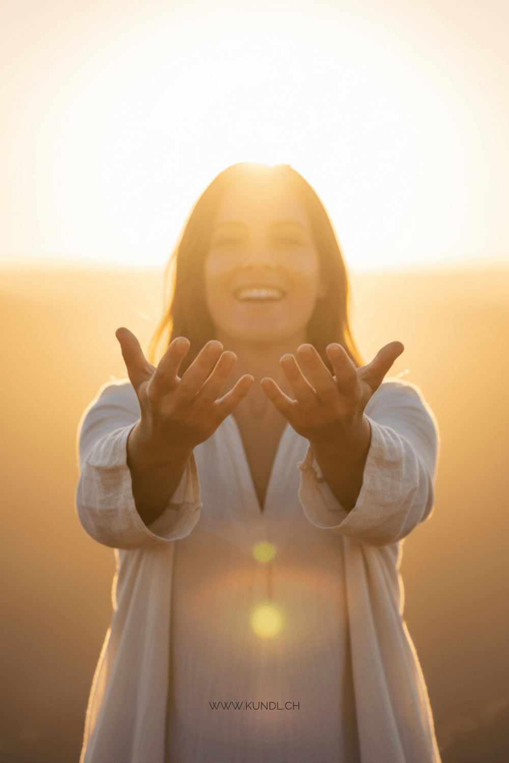 begeisterte Frau mit ausgestreckten Händen vor einem Sonnenaufgang