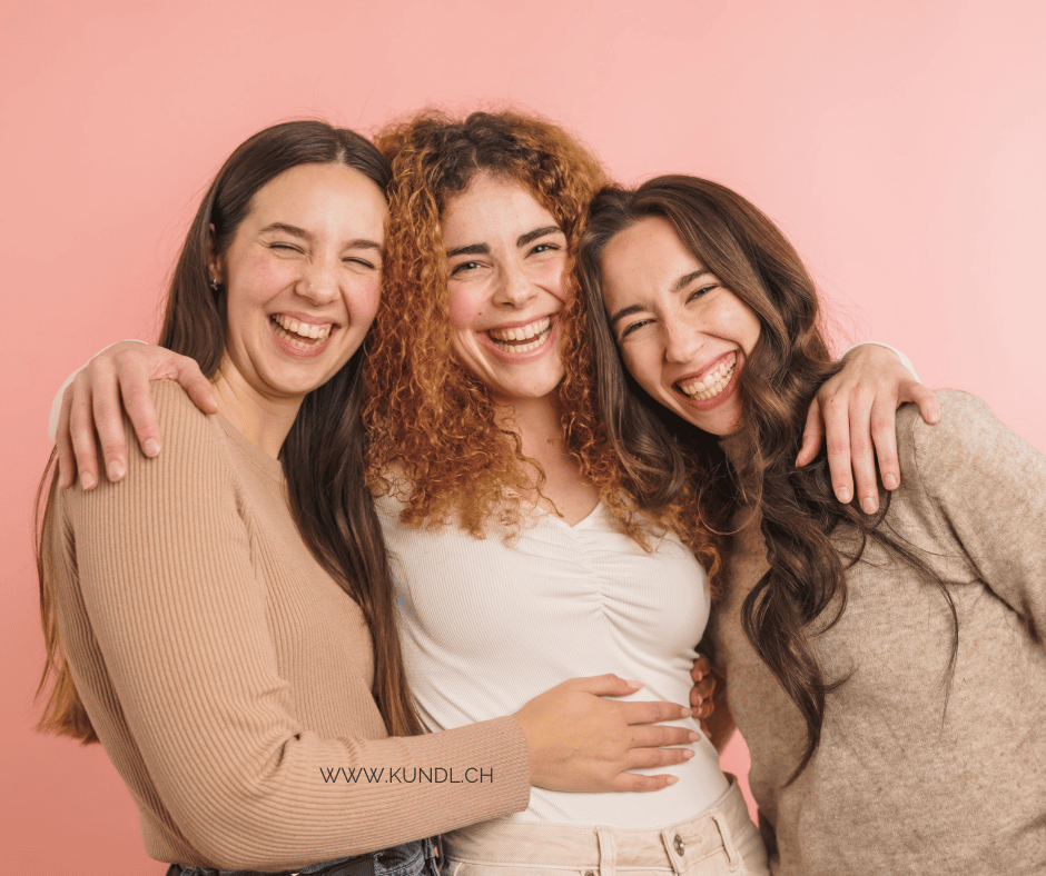 drei sich umarmende und lachenden Frauen
