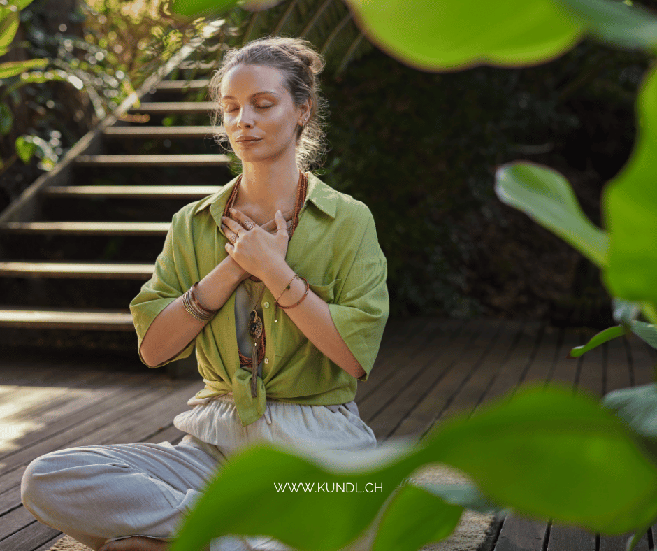 entspannte Frau in der Natur führt Atemübungen für ihr Herzchakra durch