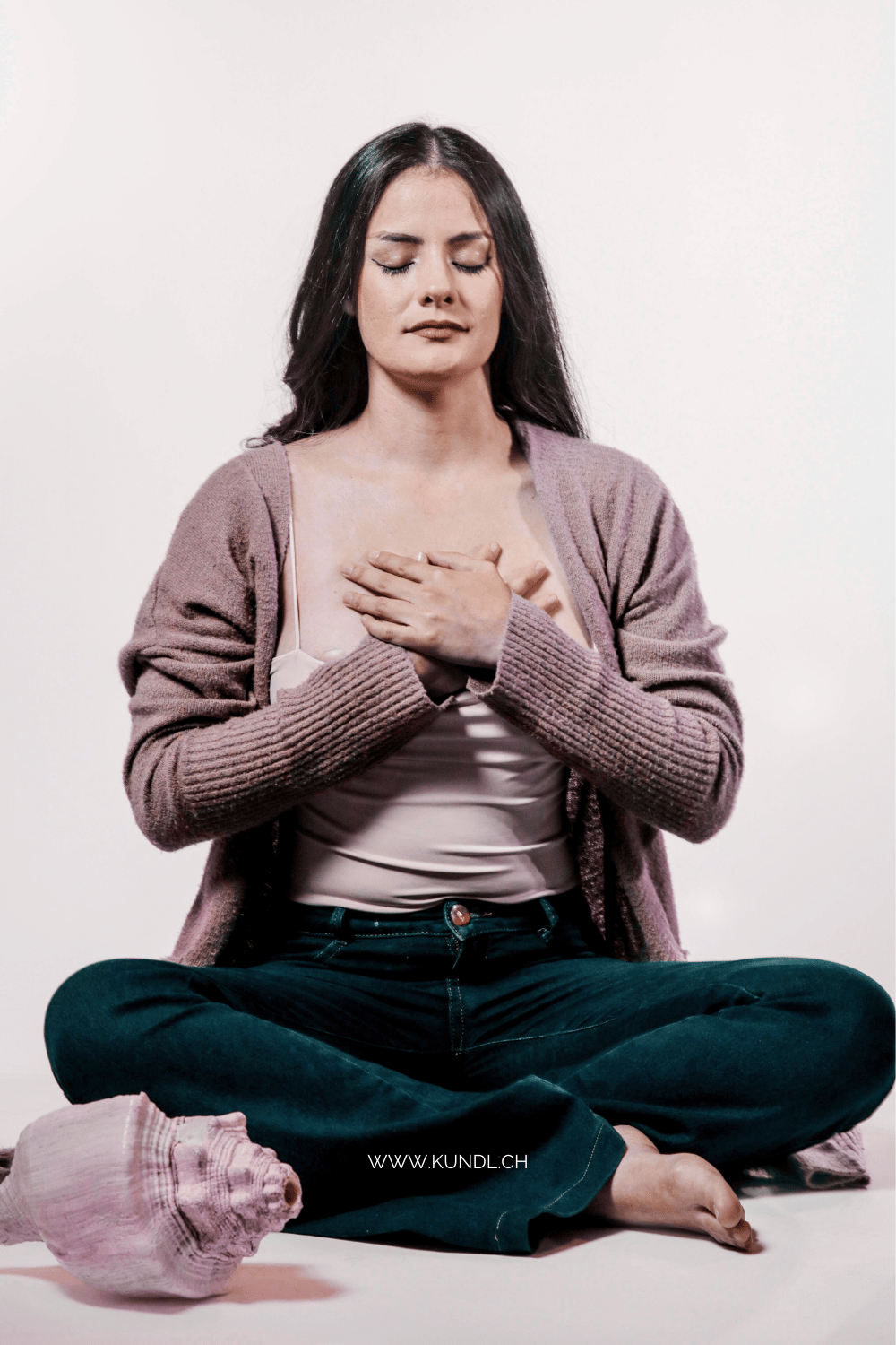 Frau mit beiden Händen auf dem Herz und bewussten Atemübungen um bei sich anzukommen