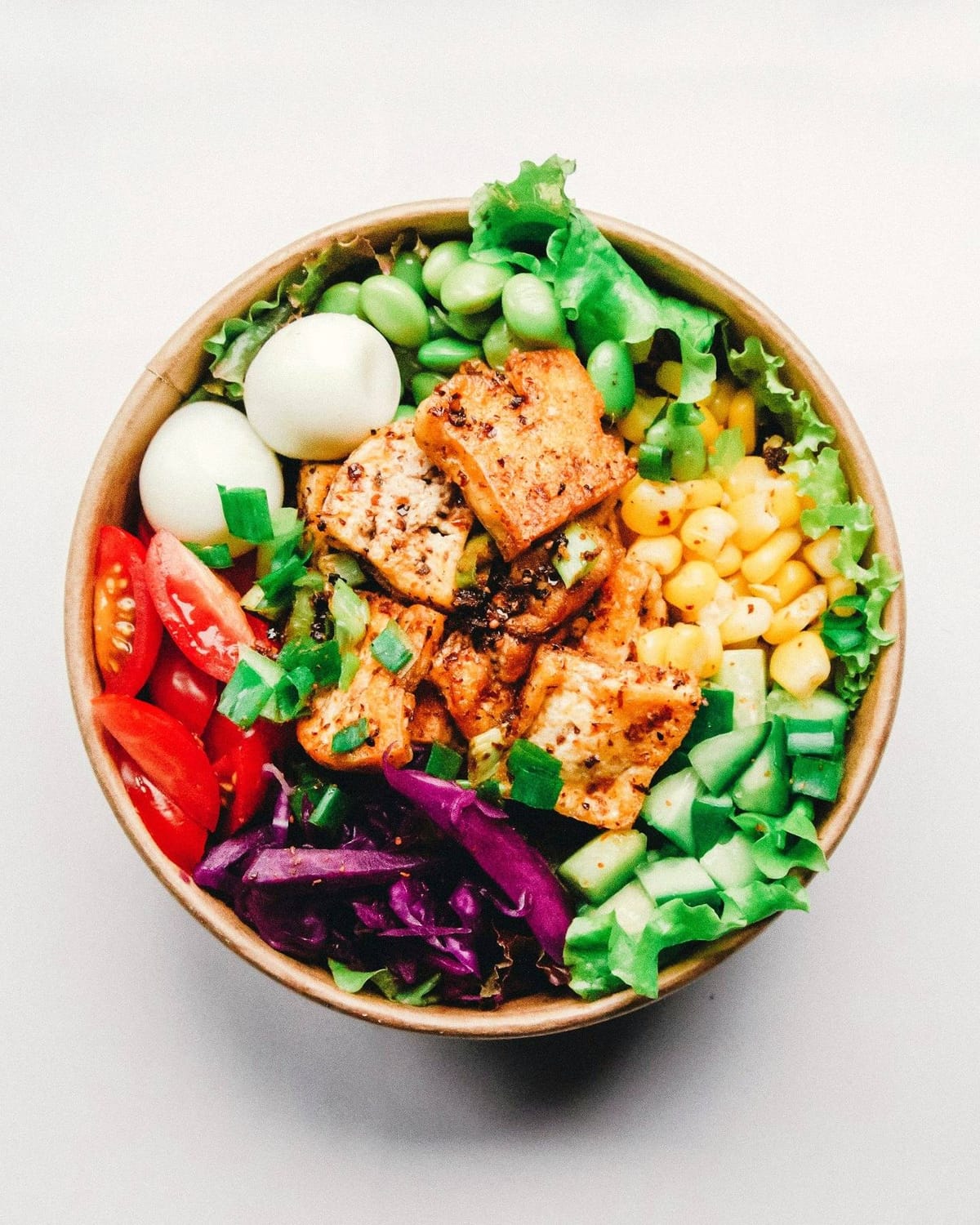 A colorful, fresh bowl of vegetables, greens and protein