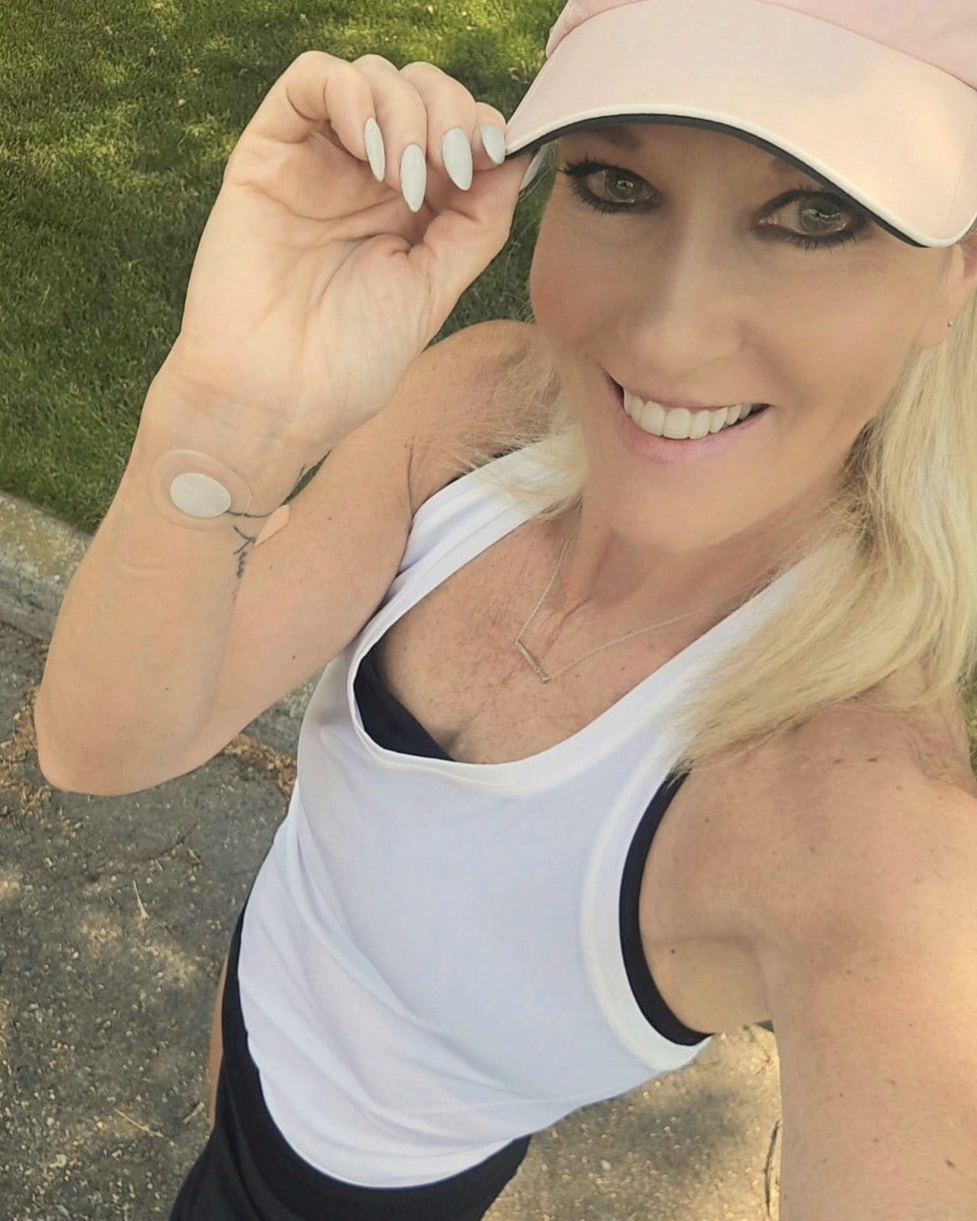 Natalie Dreger smiling in the sunshine, wearing a LifeWave X39 patch on her inner wrist