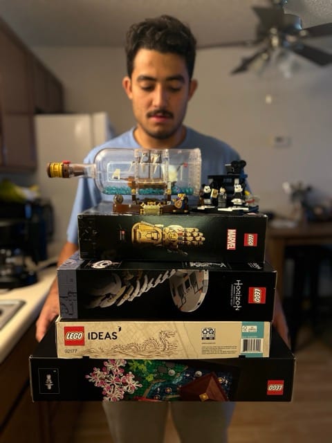 an undecided individual looking at Multiple LEGO sets and boxes to choose from