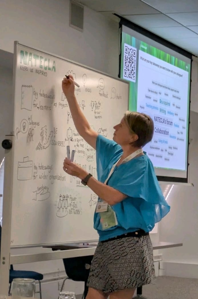 Emily Bryson taking visual notes at the NATECLA ESOL conference in Birmingham. She is visually recording on a whiteboard. 
