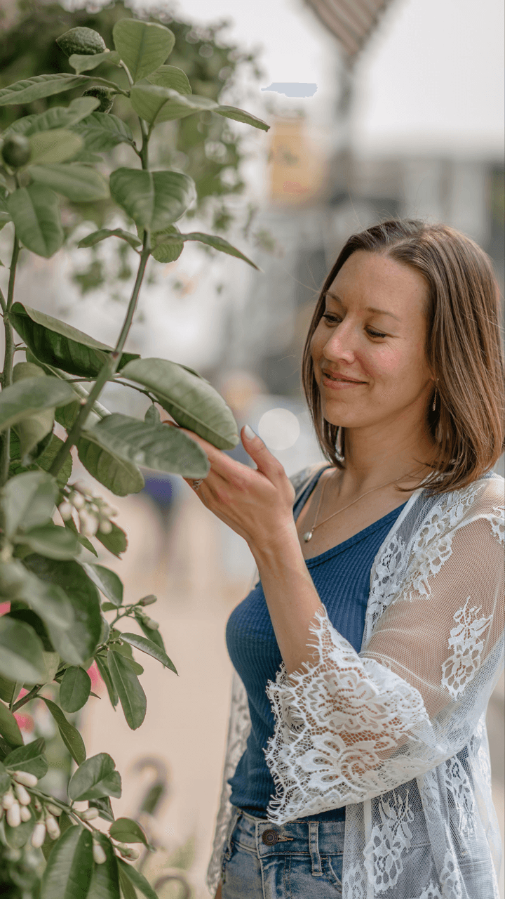 coach in lace dress by water feature with hands out and gaze raised to sky