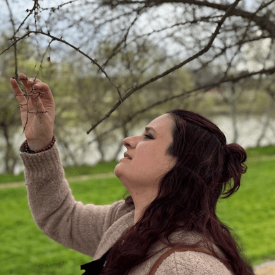 Donna di profilo osserva i boccioli di un ramo germogliato