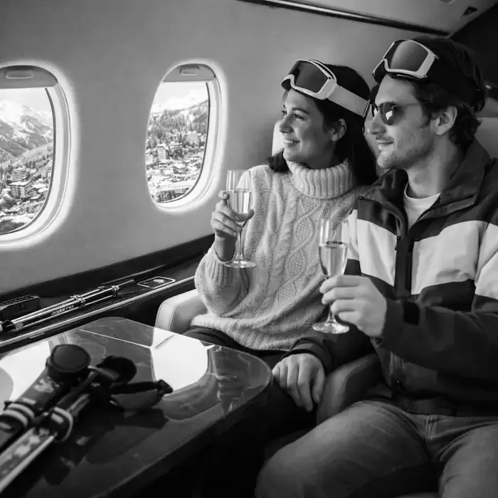 Couple profitant d'un vol à vide en jet privé vers les Alpes pour le ski