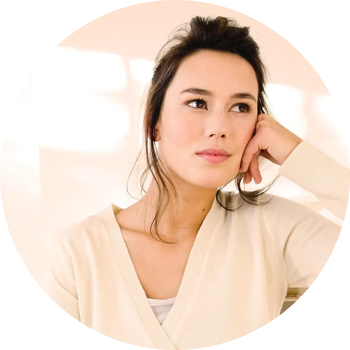 Eine Frau in einem cremefarbenen Pullover schaut nachdenklich zur Seite, während sie ihren Kopf auf die Hand stützt.