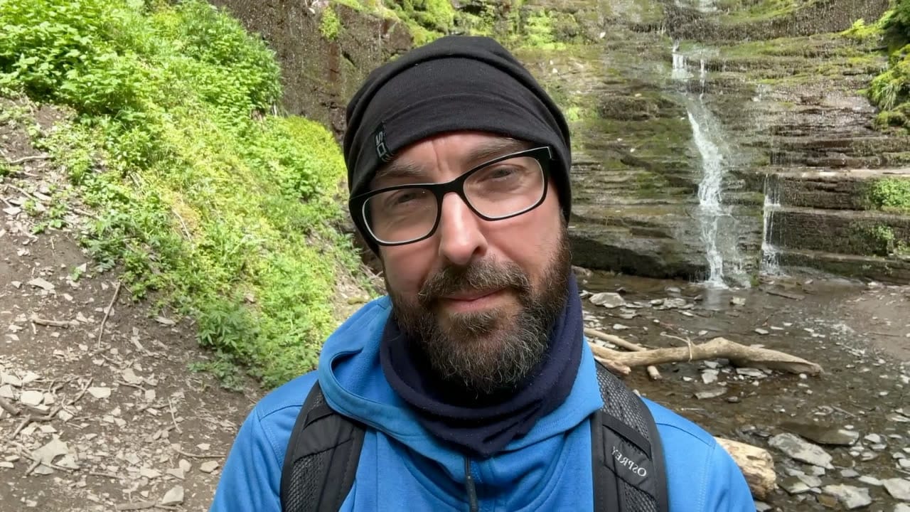 Jon walking by a waterfall in Wales