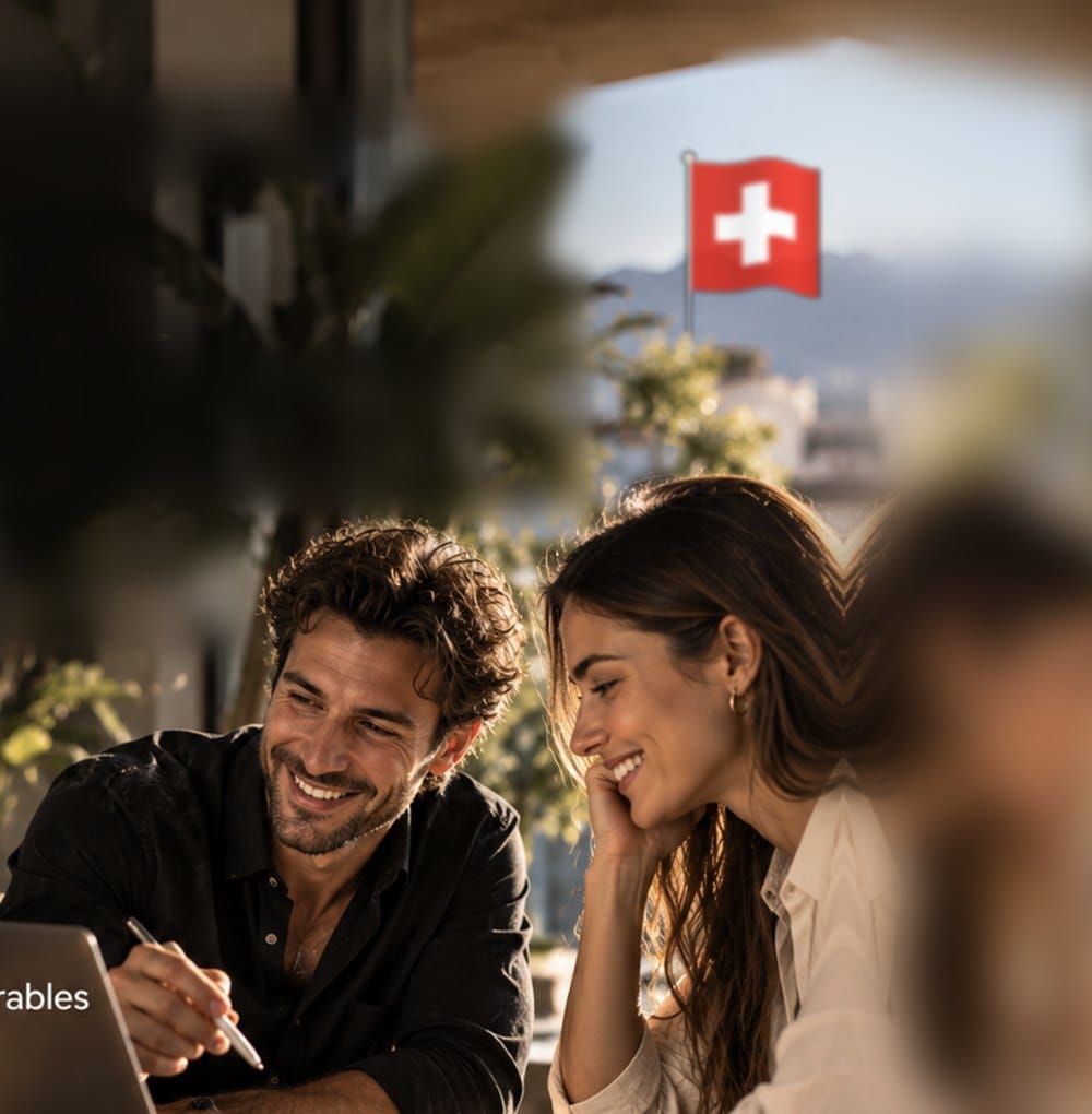 Une femme et un homme sourient en travaillant ensemble, avec un drapeau suisse en arrière-plan