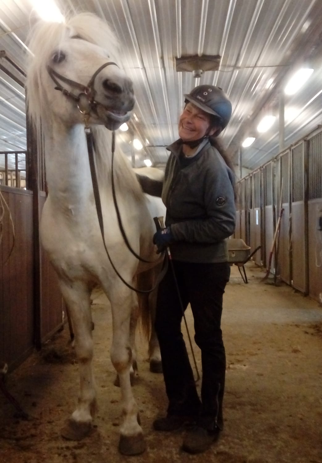 Trust and harmony between Béatrice and Hamar, an old grey stallion, sharing a complicit glance and smile.