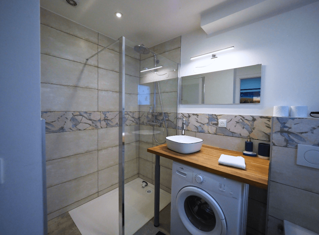 photo 1 de la salle de bain et du lave-linge de l'appartement "La Marine"
