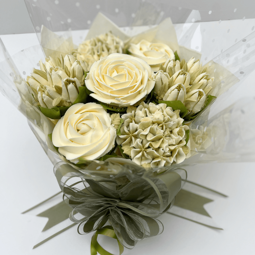 White cupcake bouquet with a hint of green, featuring buttercream roses and tulips – created by Sharon Burchall Cake Studio