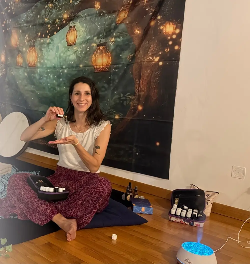 Giulia seduta sul tappeto con il kit di oli essenziali e il diffusore acceso