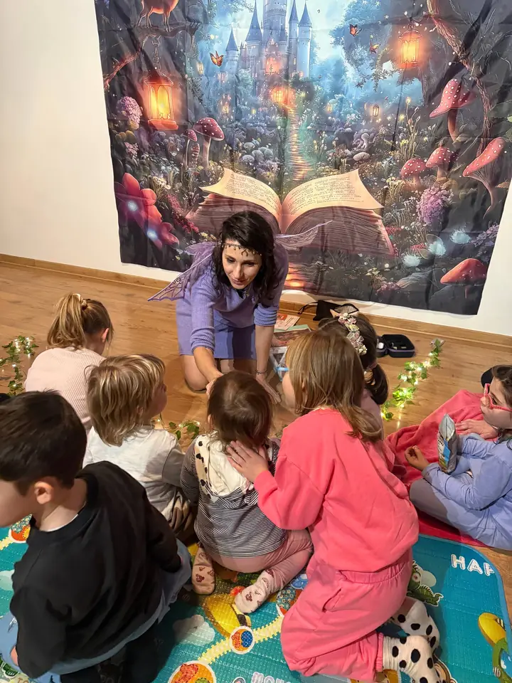Giulia con le ali da fata in mezzo a un gruppo di bambini