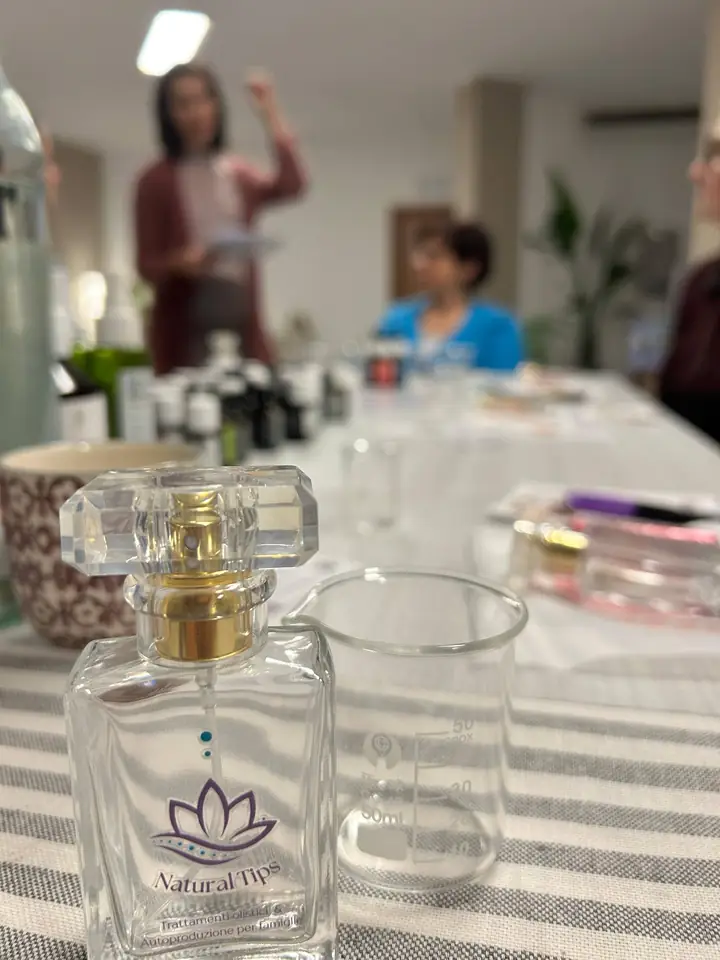 Una boccetta di profumo con il logo Natural Tips sul tavolo del laboratorio