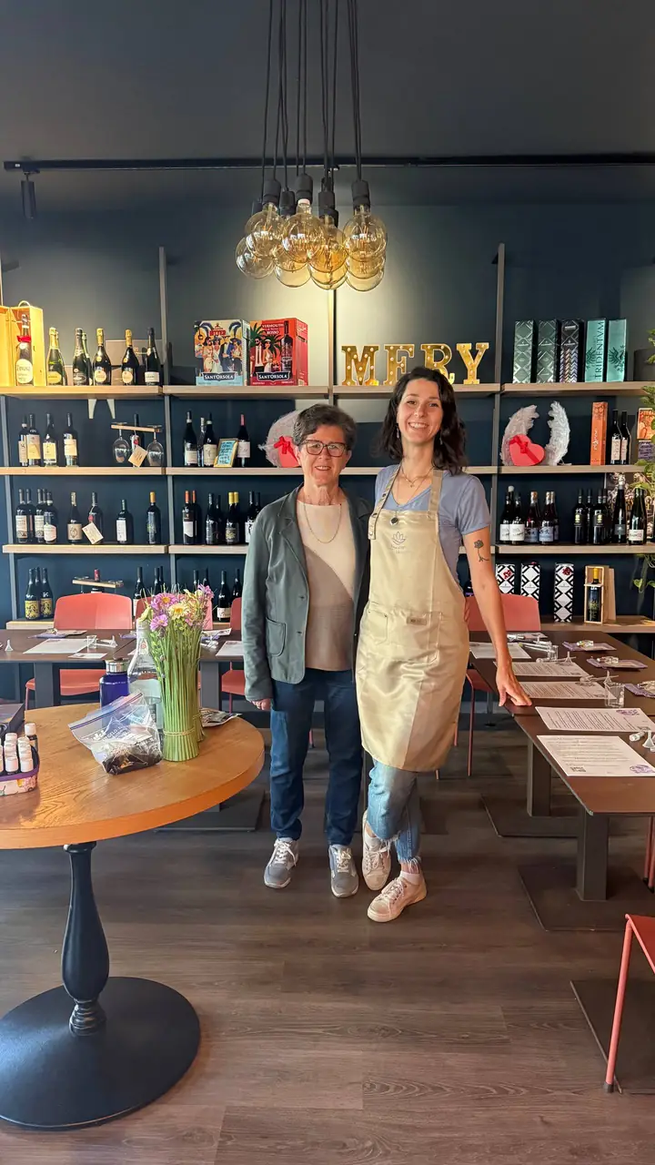 Giulia con il grembiule Natural Tips accanto a una partecipante, prima di un laboratorio