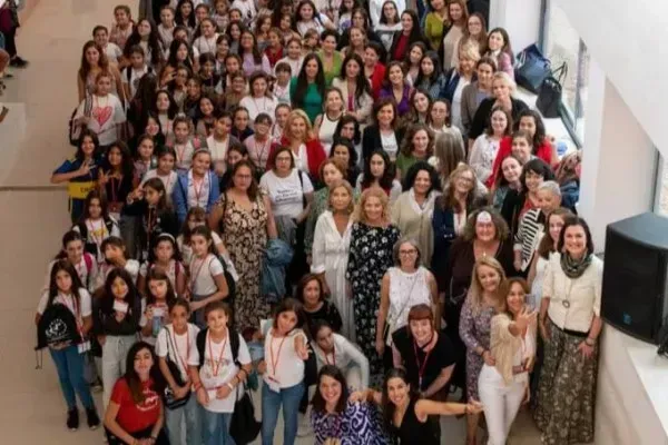 Grupo numeroso de personas reunidas en un evento educativo en un espacio interior iluminado con luz natural