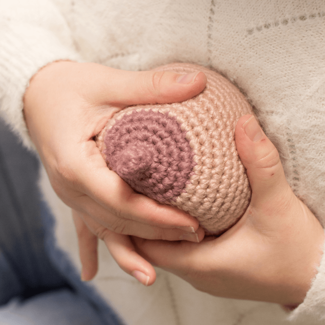 une démo d'extraction manuelle de lait sur un sein en tricot