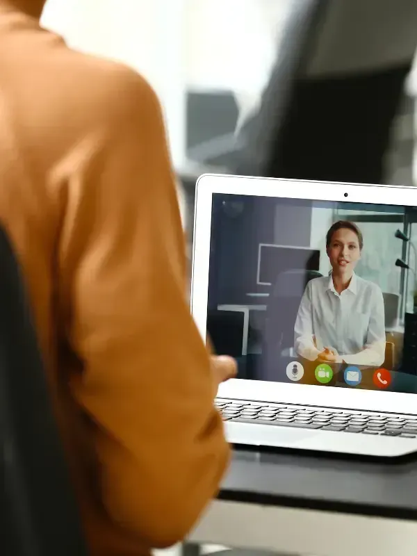 photo of person sitting in business setting with a video interview happening on his computer
