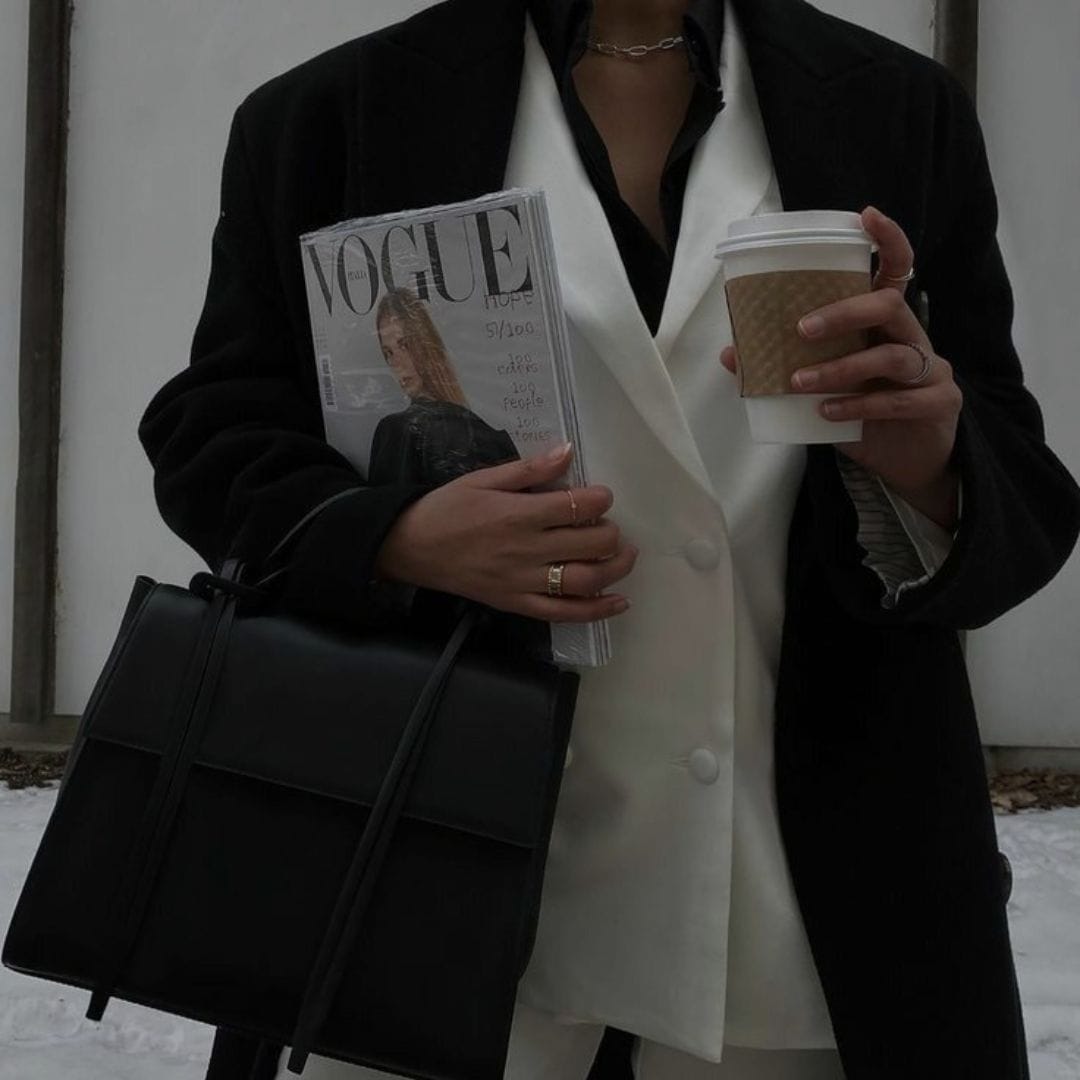 a small business seo consultant standing outside with a cup of coffee and a magazine