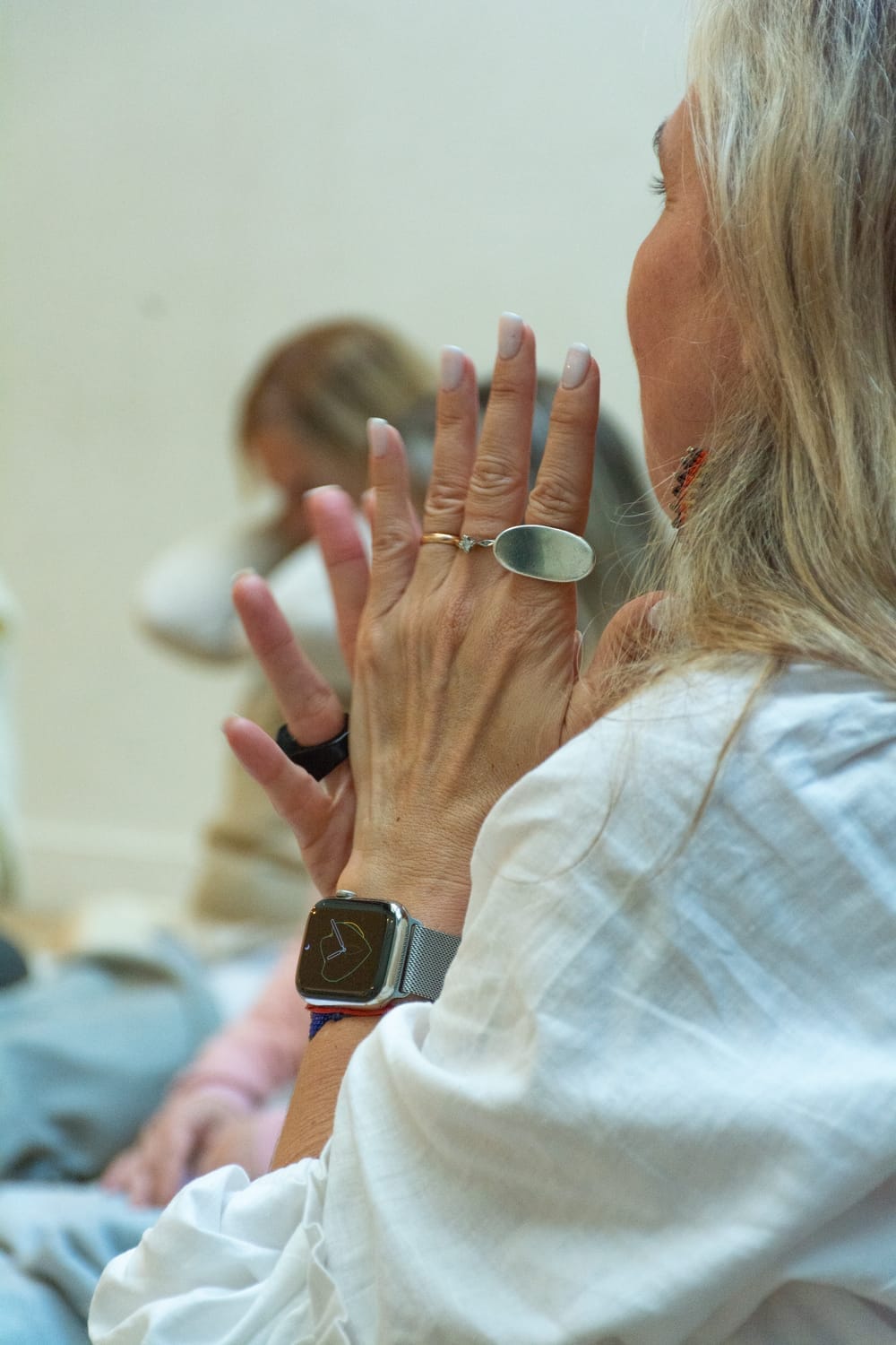 Kari Neira sentada en un taller, con la mano levantada y mirada concentrada; representa el trabajo corporal en el BodyCamp