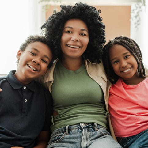 Mother with her arms around 2 kids