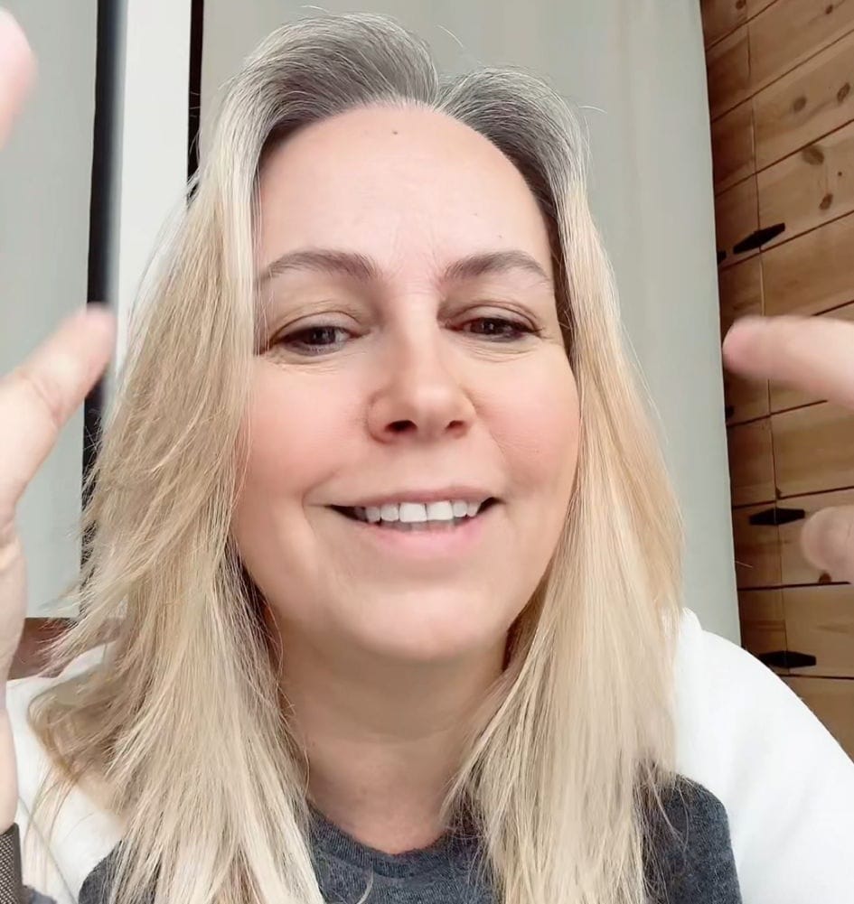 Vrouw kijkt uit op een meer en hoge bergen in de verte