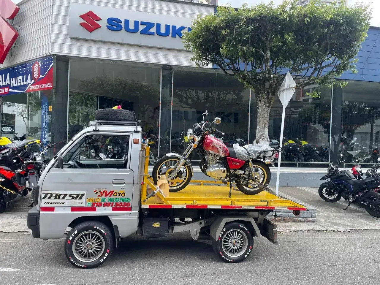 Grúa llevando moto de Suzuki