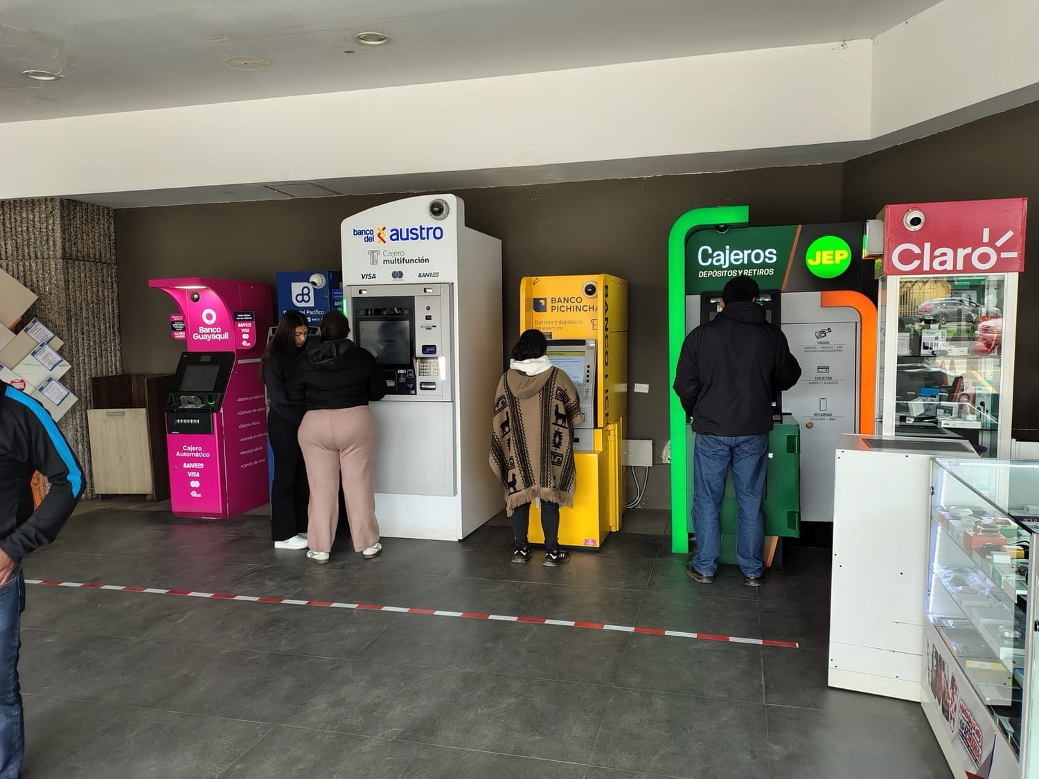 Different bank and cooperative ATMs outside a Coral in Cuenca Ecuador