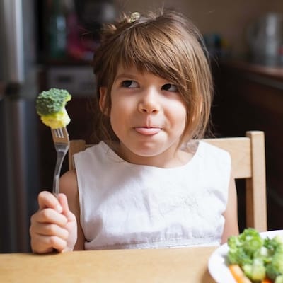 Enfant qui goûte ses légumes avec plaisir