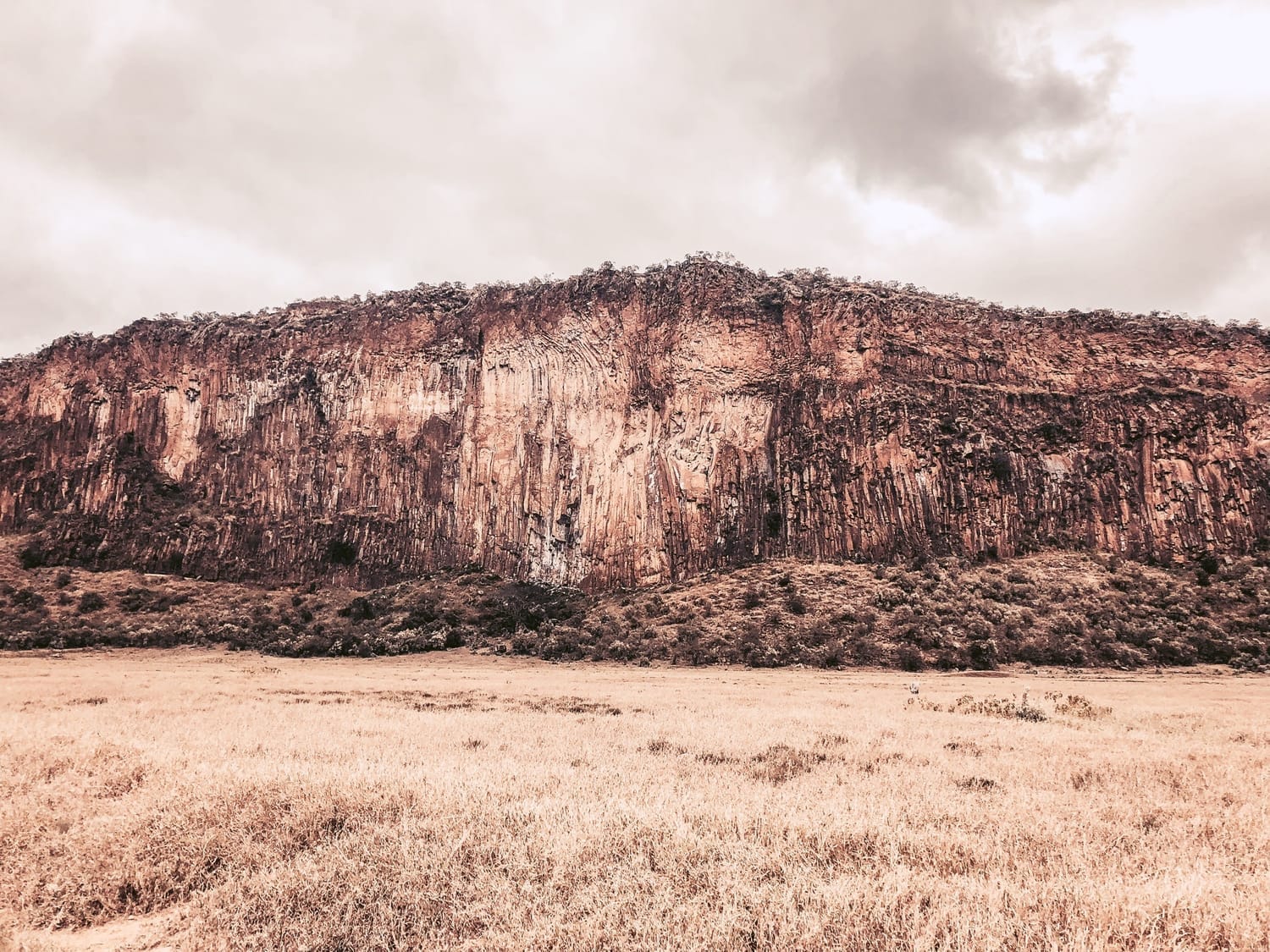 Hells Gate National Park in Kenya, showcasing dramatic red cliffs and open savannah—perfect for luxury adventure travel, custom itineraries, and boutique safari planning with insider local experiences.