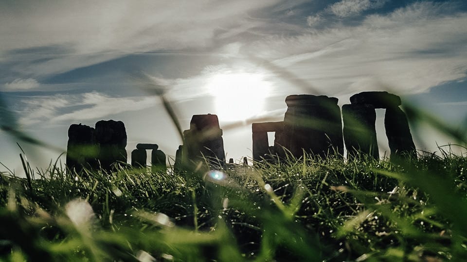 Stonehenge in England at sunrise, framed by grass and sky—an iconic cultural landmark ideal for custom itineraries, luxury travel experiences, and curated art and history journeys designed by a boutique travel planner.