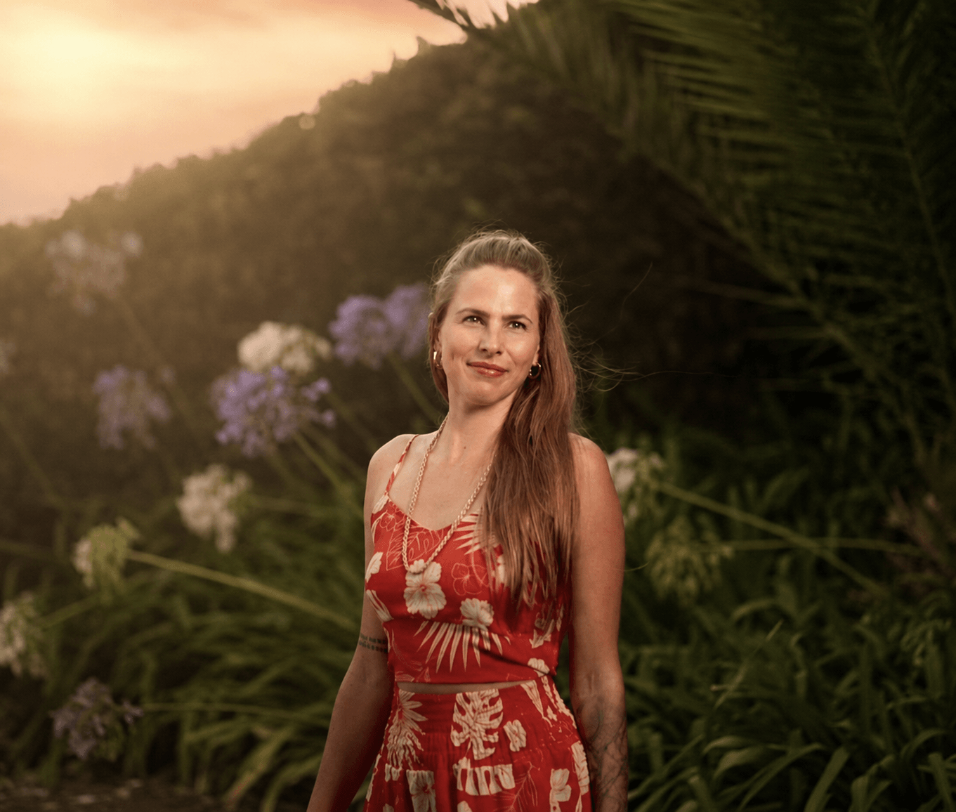 Danielle Blum outdoors in Madeira, wearing a red floral dress.