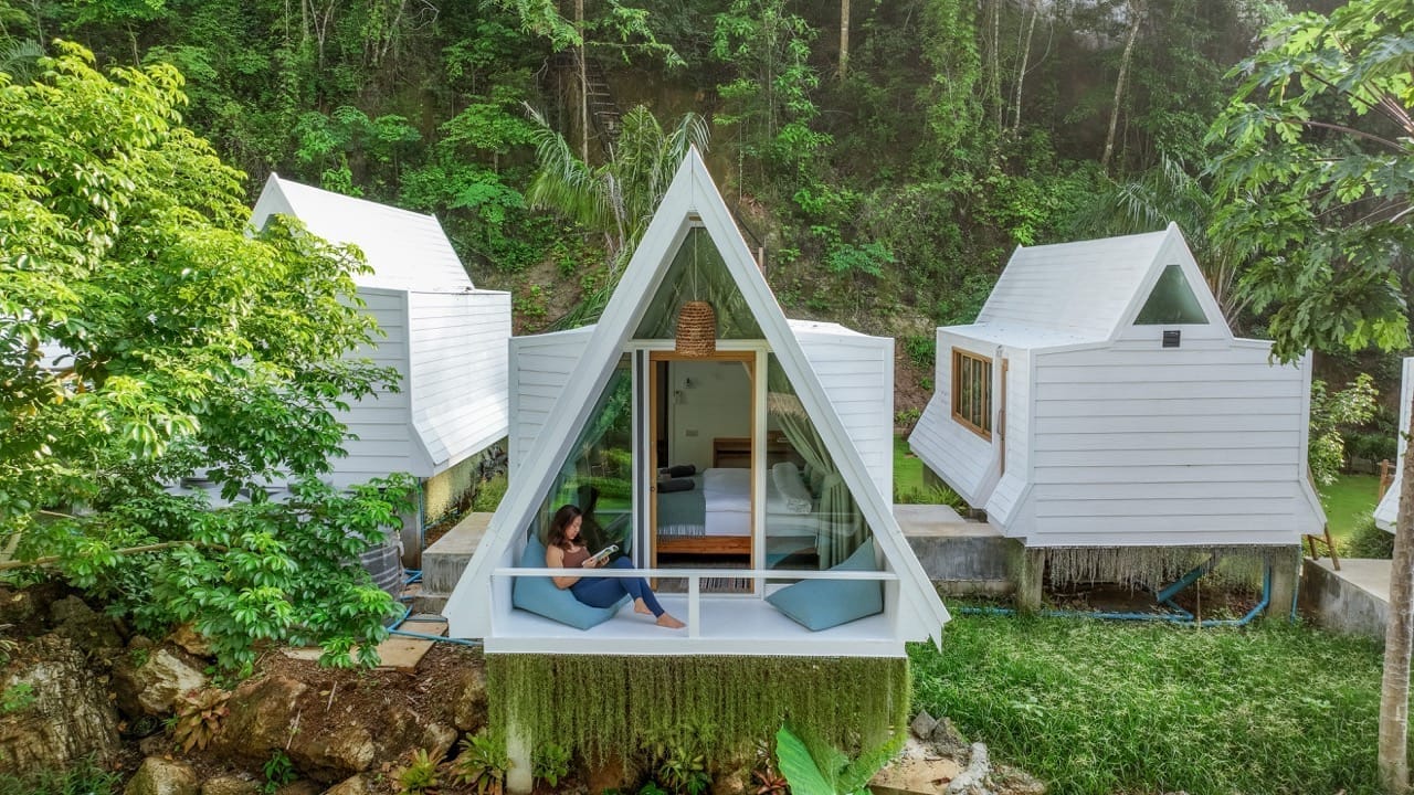 Außenansicht der weißen Bungalows des Change Retreats in tropischer Natur