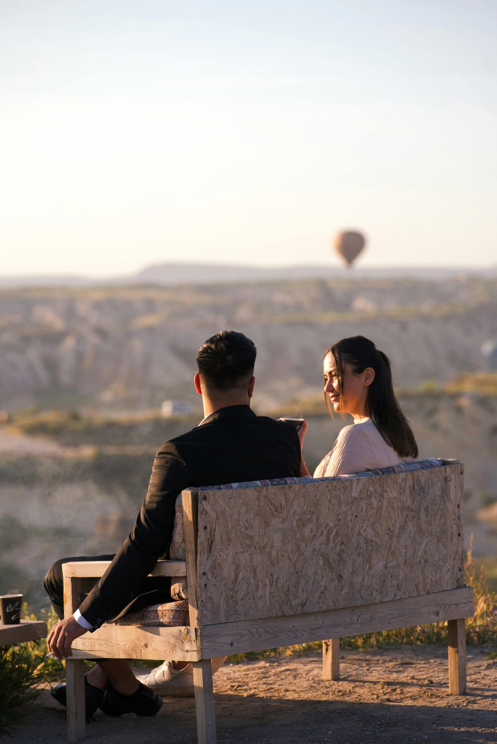 couple assis face à un paysage romantique au coucher du soleil