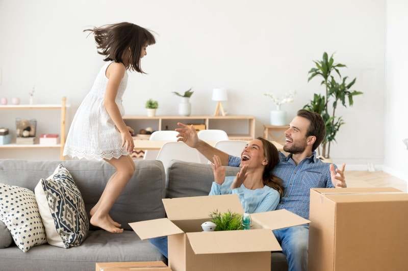 Happy family on a couch surrounded by moving boxes