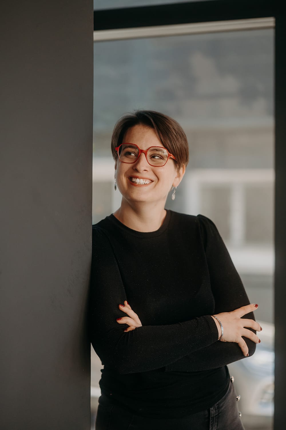 Marion Trevet, souriante, appuyée contre une baie vitrée