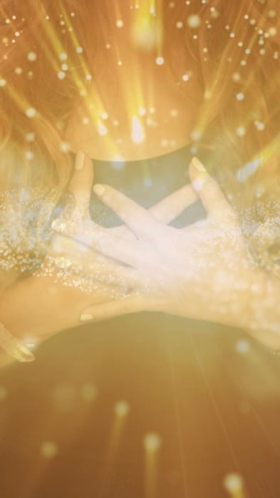 beautiful woman, eyes closed, smiling, glowing skin and with her hands in prayer, looking grateful with self love.
