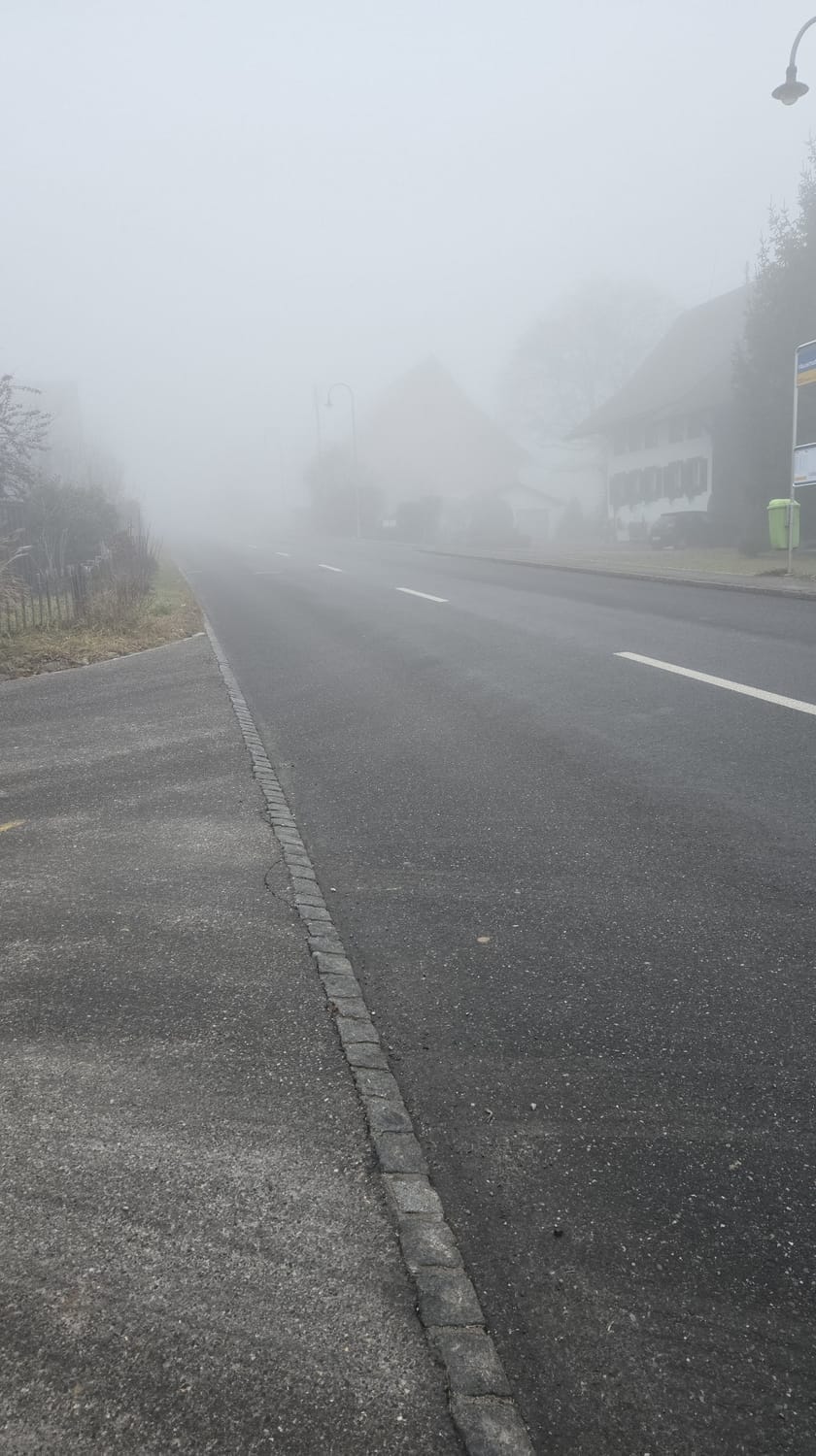 Bei Nebel auf den Bus warten