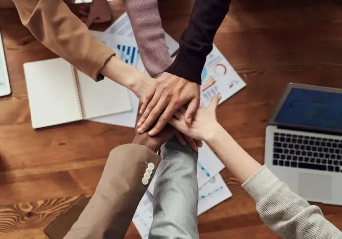 Manos que se cruzan sobre una mesa de trabajo
