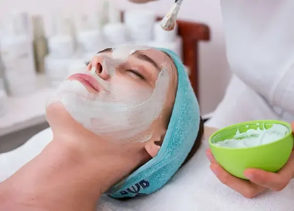 Mujer recibiendo tratamiento de belleza con enmascaramiento facial
