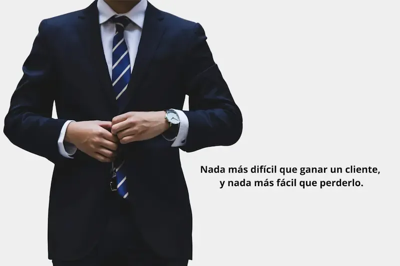 Fotografía de la mitad del cuerpo de un hombre vestido formalmente y al lado un letrero que dice: "Nada más difícil que ganar un cliente y nada más fácil que perderlo"