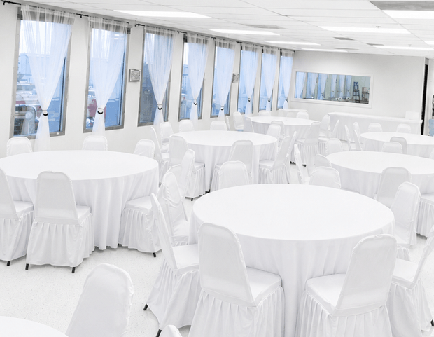 Elegant Signature Event Package with white tablecloths and white chair covers set up at TD Event Space in Denver