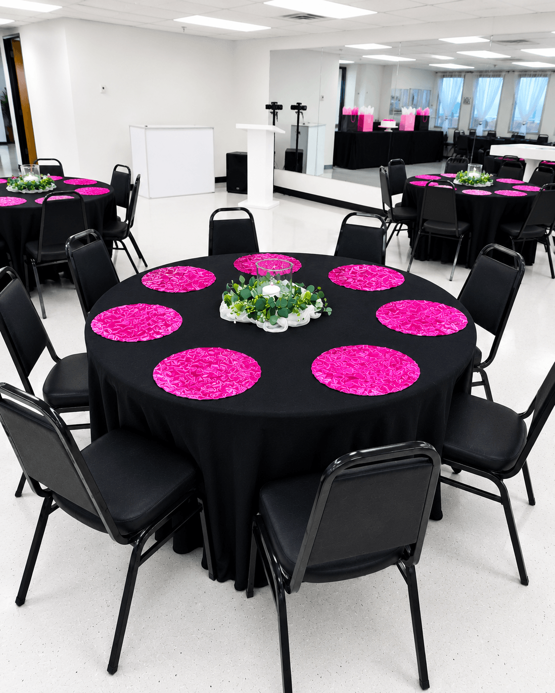 Celebrations Party Package set up at TD Event Space in Denver with black tablecloths and colorful fabric place mats & black banquet chairs.