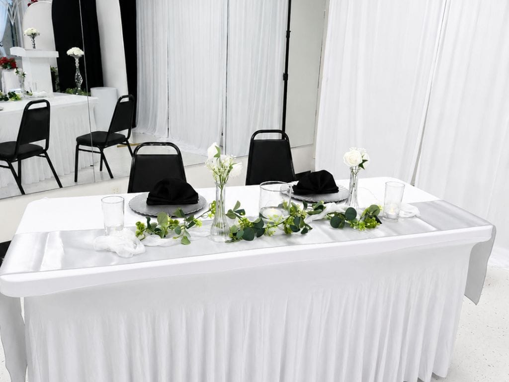 Event venue in Denver with black chairs and white tablecloths