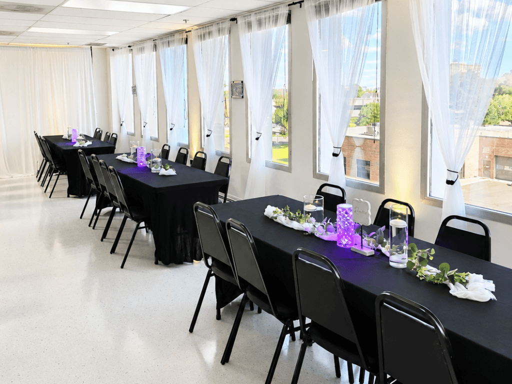 Black banquet tables with purple centerpiece lights